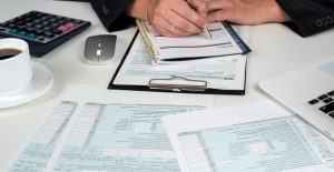 close up of male hand filling US tax form. Accountant working with 1040 form. April, tax for time